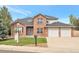 Inviting two-story brick home featuring an attached two-car garage and lush green lawn at 801 S 15Th Ave, Brighton, CO 80601