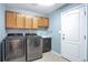 Well-lit laundry room with tile floors, cabinets above the washer and dryer, and a utility sink at 801 S 15Th Ave, Brighton, CO 80601
