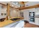 Bright kitchen, wood beams, stainless steel appliances, and an island with butcher block countertop at 25060 Montane Drive West, Golden, CO 80401