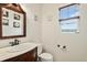 Charming half-bath with vintage-style vanity, marble countertop, and decorative floral artwork at 24285 E Wagon Trail Ave, Aurora, CO 80016