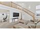 Bright living room featuring a staircase, large sectional couch, and wall-mounted TV at 24285 E Wagon Trail Ave, Aurora, CO 80016