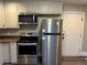 Fully equipped kitchen showcasing stainless steel appliances, including an oven, microwave, and refrigerator at 1222 Yosemite St, Denver, CO 80220
