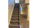 Carpeted stairs with black railing, providing access to the basement, with a glimpse of basement space at 1222 Yosemite St, Denver, CO 80220