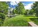 A verdant backyard with manicured lawn and scenic pond featuring mature shade trees at 6305 W 6Th Ave # C12, Lakewood, CO 80214