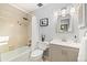 Charming bathroom featuring tub with shower, white vanity, decorative mirror and updated fixtures at 6305 W 6Th Ave # C12, Lakewood, CO 80214