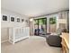 Bedroom with crib and reading chair, natural light, and access to a private outdoor patio at 6305 W 6Th Ave # C12, Lakewood, CO 80214