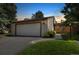 Charming home exterior featuring a two-car garage, lush lawn, and inviting curb appeal at dusk at 6305 W 6Th Ave # C12, Lakewood, CO 80214