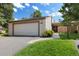 Exterior view of home with a two-car garage, beige siding, and well-maintained landscaping at 6305 W 6Th Ave # C12, Lakewood, CO 80214