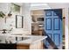 Modern kitchen with a blue pantry door and an adjacent pantry stocked with appliances and goods at 6305 W 6Th Ave # C12, Lakewood, CO 80214