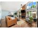 Bright living room featuring hardwood floors, large windows, a brick fireplace, and comfortable seating at 6305 W 6Th Ave # C12, Lakewood, CO 80214