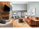 Open living room featuring a brick fireplace, hardwood floors, and lots of light from large windows at 6305 W 6Th Ave # C12, Lakewood, CO 80214