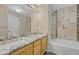 Bathroom featuring double sinks, granite countertops, and a bathtub with tiled walls at 12711 Colorado Blvd # 714G, Thornton, CO 80241