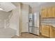 Kitchen featuring stainless steel refrigerator, granite counters, and natural wood cabinetry at 12711 Colorado Blvd # 714G, Thornton, CO 80241