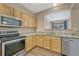 Kitchen featuring stainless steel appliances, granite countertops, and natural wood cabinetry at 12711 Colorado Blvd # 714G, Thornton, CO 80241