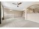 Spacious living room with staircase, modern ceiling fan, and neutral carpeting at 12711 Colorado Blvd # 714G, Thornton, CO 80241
