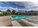 Inviting community pool with sun loungers, clubhouse, and shady gazebos against a cloudy blue sky at 12711 Colorado Blvd # 714G, Thornton, CO 80241
