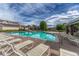 Inviting community pool with sun loungers, clubhouse, and shady gazebos against a cloudy blue sky at 12711 Colorado Blvd # 714G, Thornton, CO 80241