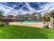 Inviting community pool with sun loungers, clubhouse, and well-maintained landscaping against a cloudy blue sky at 12711 Colorado Blvd # 714G, Thornton, CO 80241