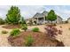 Landscaped backyard featuring mulch and stone beds, mature shrubs, and a stone patio at 7991 Heritage Dr, Thornton, CO 80602