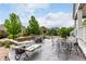 Outdoor living space features lounge chairs, dining tables, a fire pit, and landscaped garden beds at 7991 Heritage Dr, Thornton, CO 80602