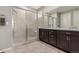 Bathroom with a glass shower, a granite countertop, and dark cabinets at 7991 Heritage Dr, Thornton, CO 80602