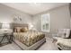 Cozy bedroom with a upholstered headboard, floral bedding, shuttered window, and accent chair; light and airy at 7991 Heritage Dr, Thornton, CO 80602
