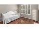 Bright bedroom with hardwood floors, a white trundle bed, and a window with plantation shutters at 7991 Heritage Dr, Thornton, CO 80602