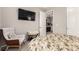 Cozy bedroom with a floral bedspread, a comfortable sitting area, and soft, neutral decor at 7991 Heritage Dr, Thornton, CO 80602