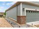 Charming home with a two-car garage, grey siding, and manicured landscaping at 7991 Heritage Dr, Thornton, CO 80602