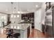 Modern kitchen with stainless steel appliances, granite counters, a breakfast bar, and dark wood cabinets at 7991 Heritage Dr, Thornton, CO 80602