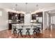 Gourmet kitchen with dark wood cabinets, granite countertops, stainless steel appliances, and an island with seating at 7991 Heritage Dr, Thornton, CO 80602