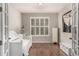 Well-lit office featuring hardwood floors, a day bed, ample natural light from shuttered windows, and a neutral color scheme at 7991 Heritage Dr, Thornton, CO 80602
