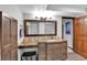 Bathroom featuring wood cabinets with a granite countertop, a mirror, and wood-look flooring at 1 Red Fox Ln, Littleton, CO 80127