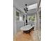 Bright bathroom with large clawfoot tub, a stylish chandelier, and bright windows at 1 Red Fox Ln, Littleton, CO 80127