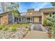 Inviting home with stone accents, wood trim, and solar panels on a sunny day at 1 Red Fox Ln, Littleton, CO 80127