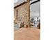 Open-concept living area with stone accent wall, modern furniture, and natural light at 1 Red Fox Ln, Littleton, CO 80127