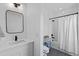 Clean bathroom with single sink vanity, tub shower with white curtain, and bronze fixtures at 8028 W 52Nd Ln # B, Arvada, CO 80002