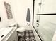Stylish bathroom with black and white patterned tile, frameless shower, and modern fixtures at 8028 W 52Nd Ln # B, Arvada, CO 80002