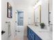 Elegant bathroom with a double sink vanity, gold fixtures, and a view of the tiled tub at 8369 W Fairview Ave, Littleton, CO 80128