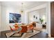 Elegant dining room with a modern light fixture, a glass-top table, and a view into the stylish living area at 8369 W Fairview Ave, Littleton, CO 80128