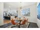 Well-lit dining area with modern decor, a glass table, and a view into the stylish, open kitchen at 8369 W Fairview Ave, Littleton, CO 80128