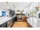 Well-lit kitchen featuring modern appliances, custom cabinetry, and a center island at 8369 W Fairview Ave, Littleton, CO 80128