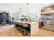 Open kitchen with a large center island, modern stainless steel appliances, and hardwood floors at 8369 W Fairview Ave, Littleton, CO 80128