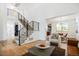 Open living area with a modern staircase, hardwood floors, and seamless flow into the adjacent dining space at 8369 W Fairview Ave, Littleton, CO 80128