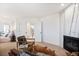 Open-concept living room with a fireplace, leather chairs, and view into a furnished bedroom at 8369 W Fairview Ave, Littleton, CO 80128