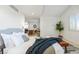 Bright main bedroom with a plush bed, decorative pillows, and views of the connected living room at 8369 W Fairview Ave, Littleton, CO 80128
