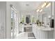Bright bathroom with double vanity, marble countertop, and French doors leading to a garden at 1991 E Alameda Ave # 14, Denver, CO 80209