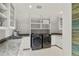 Bright laundry room with granite counters, white cabinets, built in storage shelves, and modern washer and dryer at 1991 E Alameda Ave # 14, Denver, CO 80209