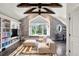 Bright living room with vaulted ceiling, exposed wood beams, and custom built-in shelving at 1991 E Alameda Ave # 14, Denver, CO 80209