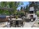 Outdoor kitchen and dining area features grill, cabinets and comfortable seating around a round table and outdoor fireplace at 1991 E Alameda Ave # 14, Denver, CO 80209